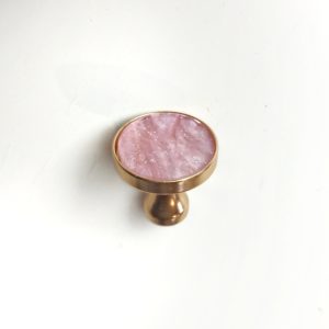 Goldener Möbelgriff mit rosa Innenteil, was schimmert und glitzert